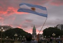 Un hombre despliega la bandera patria frente al Congreso de la Nación |(Muhammed Emin Canik - Agencia Anadolu).