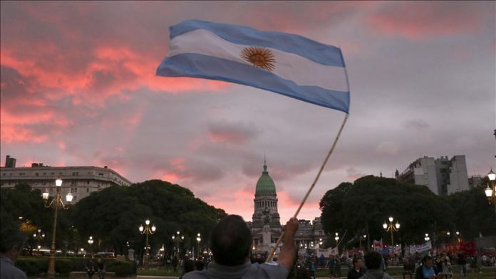 Un hombre despliega la bandera patria frente al Congreso de la Nación |(Muhammed Emin Canik - Agencia Anadolu).