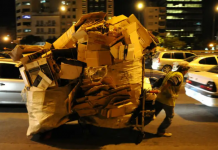 Un cartonero arrastra su carro repleto en plena noche porteña. El hogar del cartonero