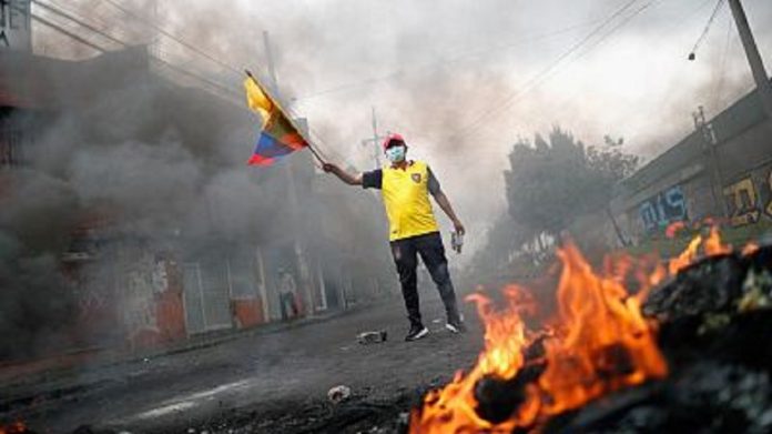 Un hombre sujetando una bandera de Ecuador protestando contra las políticas económicas del Gobierno de Guillermo Lasso en una calle de Quito. REUTERS/ADRIANO MACHADO