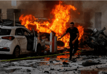 Un hombre corre por una carretera mientras el fuego arde después de que se lanzaran cohetes desde la Franja de Gaza, en Ashkelon, Israel. Foto: REUTERS/Amir Cohen