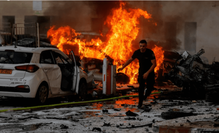 Un hombre corre por una carretera mientras el fuego arde después de que se lanzaran cohetes desde la Franja de Gaza, en Ashkelon, Israel. Foto: REUTERS/Amir Cohen