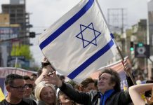 Javier Milei, de la Libertad Avanza, sostiene una bandera israelí durante su caravana por Lomas de Zamora, el lunes 16 de octubre de 2023 Natacha Pisarenko - AP